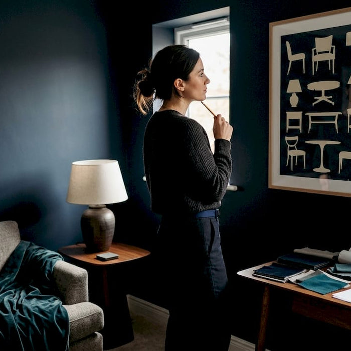 Interior designer examining furniture silhouette poster