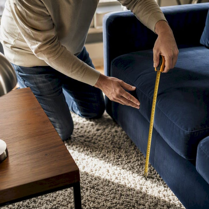 Hands measuring seat height of sofa