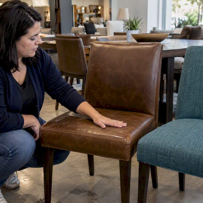 Shopper comparing leather and fabric dining chairs