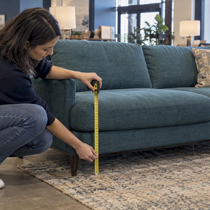 Shopper checks sofa seat height in showroom